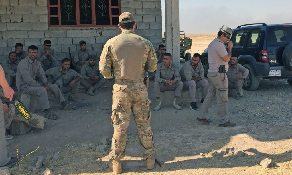 Special operations trainer explaining to Iraqi counterparts how to properly use SoA-provided metal detectors during security operations