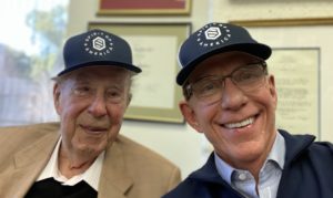 Former Secretary of State George Shultz with Spirit of America CEO Jim Hake, both wearing Spirit of America ballcaps