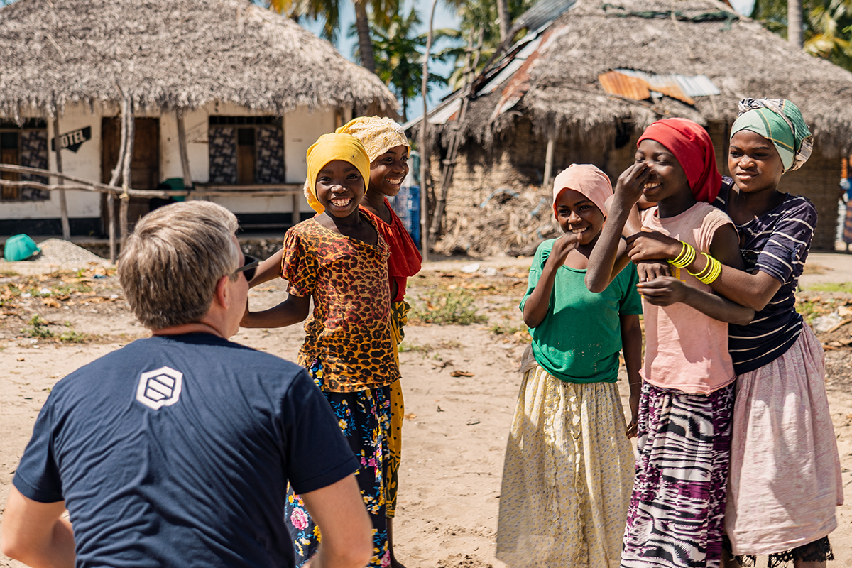 Mozambican children smile and talk with a Spirit of America team member