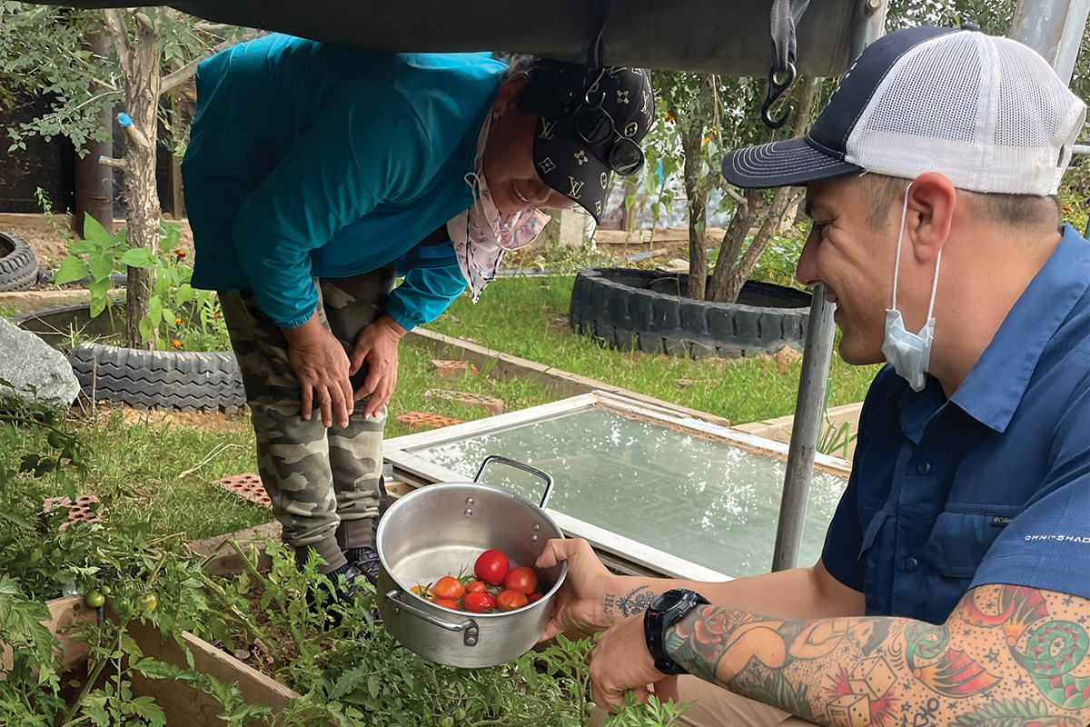 Mongolia-photo SoA team member Danny Santos with Mongolian farmer in greenhouse with tomatoes